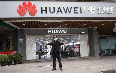 A man wearing a protection mask for coronavirus stretches in front of Huawei store in Guangzhou, Guangdong Province, China, 05 February 2020. ANSA/ALEX PLAVEVSKI
