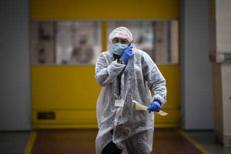 Dipendenti indossano mascherine e guanti protettivi a prevenzione della diffusione del Covid-19, durante il turno di lavoro, presso lo stabilimento industriale di packaging farmaceutico Eurpack di Aprilia, Roma. 21 aprile 2020
ANSA/MASSIMO PERCOSSI