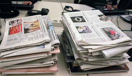 Due mazzette di giornali su una scrivania in un'agenzia di stampa, Roma, 4 dicembre 2011. ANSA / FABIO CAMPANA