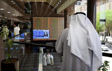 epa08280409 People stand inside the hall as they observe screens showing the development of the Boursa Kuwait national stock market, in Kuwait City, Kuwait, 09 March 2020. According to media reports, Kuwait stock exchange on 09 March stopped trading after main index dropped by 10 percent as OPEC failure to reach an agreement on production brought oil prices down by more than 30 percent. Fears over Coronavirus effects on the economy and the oil crisis also affected stock markets in Gulf countries, with Saudi and UAE share went down and Saudi oil giant Aramco shares have lost 10 percent of their value.  EPA/NOUFAL IBRAHIM