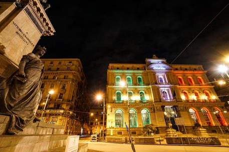 Il palazzo della Borsa di Napoli, simbolo dell'economia del territorio illuminato con i colori della bandiera italiana a Napoli 24 Aprile 2020. ANSA/CESARE ABBATE/