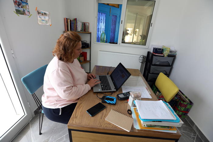 epa08332098 Caroline Laffont French, 44, teacher at a French primary school, works from her home in La Marsa, in the suburbs of Tunis, Tunisia, 30 March 2020. Most companies, are opting for teleworking to limit the spread of the covid-19 coronavirus. As the school closed their doors since the beginning of the Covid-19 crisis, the French schools decided to offer courses over the internet. Caroline gives courses everyday behind her computer screen from 2pm to 5pm local time. She says that she has much more work when she is at home than inside the school, because she has also have to help her daughter in her courses.  EPA/MOHAMED MESSARA  ATTENTION: This Image is part of a PHOTO SET