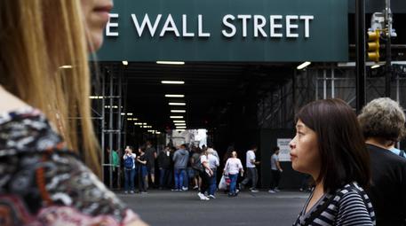 epa07062571 People walk past a sign for a building on Wall Street near the New York Stock Exchange in New York, New York, USA, on 01 October 2018. The Dow Jones industrials closed up nearly 200 points today.  EPA/JUSTIN LANE