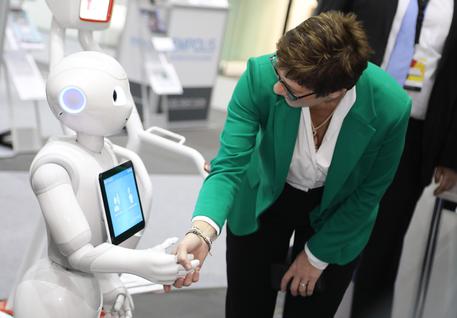 epa07216088 The new elected chairwoman Annegret Kramp-Karrenbauer (R) meets a robot during her visit at the exhibition area on the sidelines of the 31st German Christian Democratic Union (CDU) Party Congress, in Hamburg, Germany, 08 December 2018. Annegret Kramp-Karrenbauer was elected as the new CDU chairwoman on 07 December with the debate going on over the fundamental political orientation of the CDU after Chancellor Merkel will no longer hold this office.  EPA/DAVID HECKER