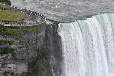 epa06029838 People in Niagara Falls, USA, view the Horseshoe Falls, 15 June 2017. The Niagara River forms the international border between the USA and Canada.  EPA/WARREN TODA