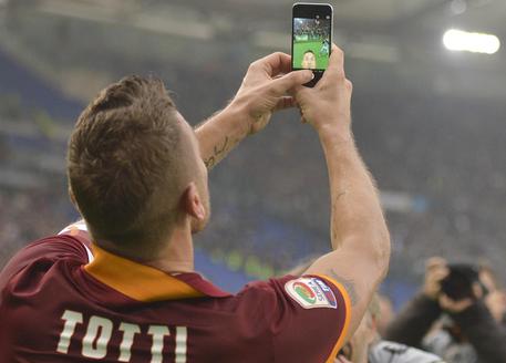 Roma's Francesco Totti celebrates taking a selfie after scoring during a Serie A soccer match between Roma and Lazio at Rome's Olympic stadium, Sunday, Jan. 11, 2015. (AP Photo/Luciano Rossi) [Credit: ANSA]