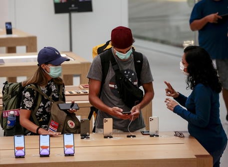 epa08214501 An Apple store saleswoman (R) interacts with tourist wearing protective masks at the Apple Store inside the Jewel Changi Airport mall in Singapore, 13 February 2020. Singapore's Ministry of Health has reported 50 cases of novel coronavirus infection, as well as 15 cases of patients that have been discharged. The disease caused by the SARS-CoV-2 has been officially named Covid-19 by the World Health Organization (WHO). The outbreak, which originated in the Chinese city of Wuhan, has so far killed at least 1,369 people with over 60,000 infected worldwide, mostly in China.  EPA/WALLACE WOON