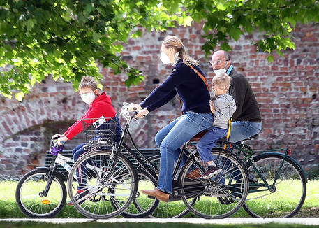 Una famiglia  in bicicletta al parco Sempione di Milano  nel primo giorno della 