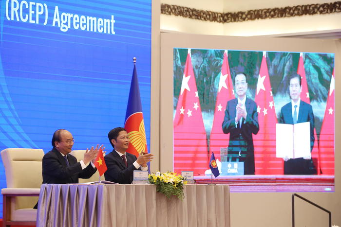 epa08821138 Vietnam's Prime Minister Nguyen Xuan Phuc (L) and Minister of Industry and Trade Tran Tuan Anh (R) during the virtual signing ceremony for the Regional Comprehensive Economic Partnership (RCEP) in Hanoi, Vietnam, 15 November 2020. The virtual 37th ASEAN Summit and related summits take place from 12 to 15 November 2020 at the International Convention Center (ICC) in Hanoi.  EPA/LUONG THAI LINH