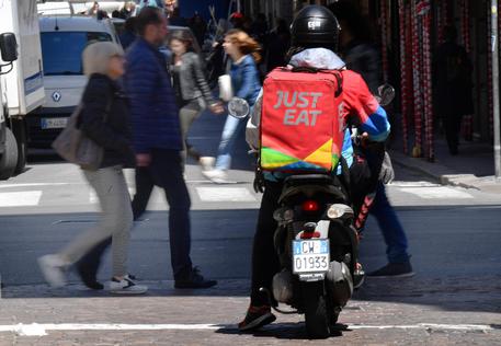 Un rider della Just Eat impegnato in una consegna nel centro della citta', Genova, 30 aprile 2019. ANSA/LUCA ZENNARO