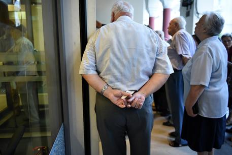 Pensioners wait  to withdraw a maximum of 120 euros ($134) outside a bank in the northern Greek port city of Thessaloniki, Friday, July 10, 2015. Greece's Prime Minister Alexis Tsipras will seek backing for a harsh new austerity package from his party Friday to keep his country in the euro. (ANSA/AP Photo/Giannis Papanikos)