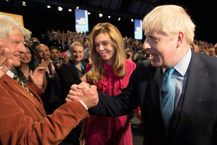 epa07889366 Prime Minister Boris Johnson leaves the stage with his partner Carrie Symonds as he is congratulated by his father Stanley Johnson after delivering his speech during the Conservative Party Conference at the Manchester Convention Centre, Britain, 02 October 2019.  EPA/STEFAN ROUSSEAU / POOL