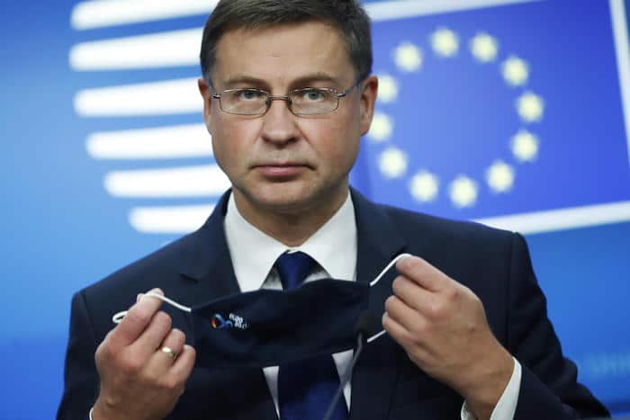 epa08809646 European Commission Vice-President Valdis Dombrovskis takes off his protective face mask prior to addressing a media conference after a meeting of EU trade ministers, in videoconference format, at the European Council building in Brussels, Belgium, 09 November 2020. European Union trade ministers exchanged views on the trade policy review and relations with China and the United States.  EPA/FRANCISCO SECO / POOL