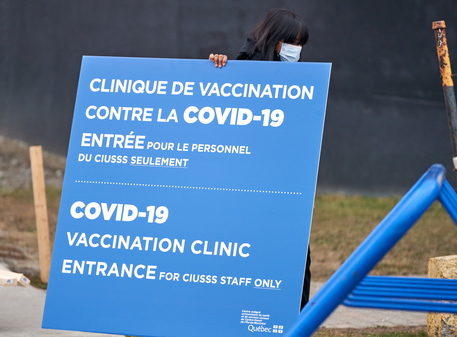 epa08883886 Workers set up signs at the first center to recive Covid-19 vaccine in Montreal, Canada, 14 December 2020. The first patients in Canada will be vaccinated there with the Pfizer BionNtech vaccine.  EPA/ANDRE PICHETTE