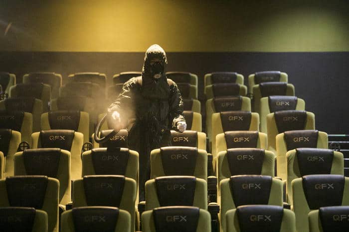 epa08902247 A staff member in protective suit sprays disinfectant inside a cinema hall ahead of its reopening to the public in Kathmandu, Nepal, 24 December 2020, after nine month of closing due to the coronavirus disease (COVID-19) pandemic.  EPA/HEMANTA SHRESTHA