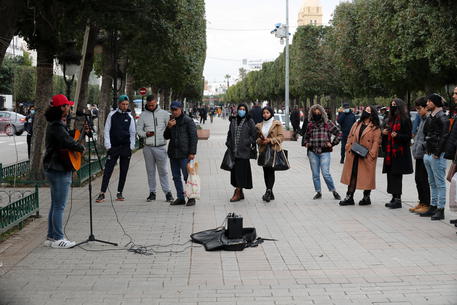 epa08935458 A man plays the guitar on Habib Bourguiba avenue in Tunis, Tunisia, 13 January 2021. The Tunisian government has decreed a nationwide general containment throughout for four days starting 14 January to curb the spread of the Sars-CoV-2 coronavirus which causes the Covid-19 disease.  EPA/Mohamed Messara