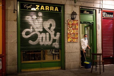 epa08965246 A waiter closes a bar in central Madrid, Spain, 25 January 2021. Madrid's regional government has imposed an earlier closing of bars and restaurants at 9pm and a general lockdown curfew at 10pm to curb a further spike of Covid-19 cases in the country.  EPA/Rodrigo Jimenez