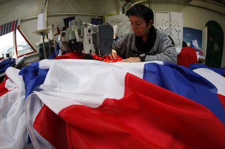 Michelle Houste, 52, sews a French flag at the Doublet factory, which specializes in making the national flag, in Avelin, near Lille, northern France, Thursday, Nov. 26, 2015. Flying the French flag in a garden  for decades considered bad taste or a symbol of ultranationalism  is now back in favor with the French after the deadly attacks on Paris. (ANSA/AP Photo/Michel Spingler)