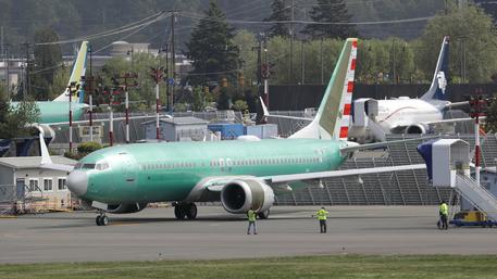 Workers stand near a Boeing 737 MAX 8 jetliner being built for American Airlines prior to a test flight, Wednesday, May 8, 2019, in Renton, Wash. Passenger flights using the plane remain grounded worldwide as investigations into two fatal crashes involving the airplane continue. (ANSA/AP Photo/Ted S. Warren) [CopyrightNotice: Copyright 2019 The Associated Press. All rights reserved.]