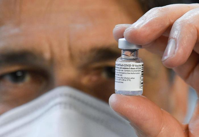 Doctor Roland Kolepke holds a vial of the Pfizer-BioNTech Covid-19 vaccine at the regional corona vaccination centre in Ludwigsburg, southern Germany, on January 22, 2021. (Photo by THOMAS KIENZLE / AFP)