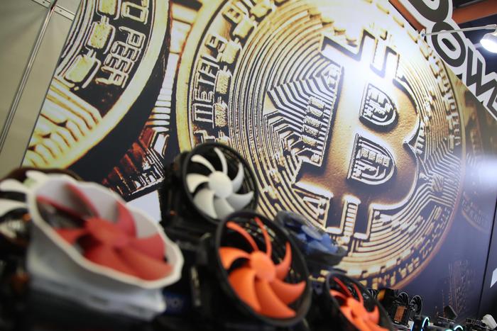 epa06785820 A bitcoin logo is seen next to computer fans during the Computex 2018 in Taipei, Taiwan, 05 June 2018. The Computex 2018 event will run from 05 June to 09 June 2018 and will exhibit innovations from various computer designers.  EPA/RITCHIE B. TONGO