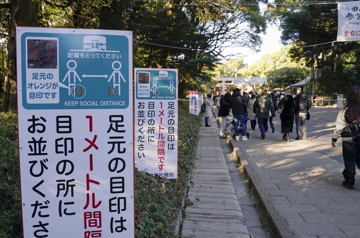 epa08912221 Signboards request visitors observing social distancing when visitors pray for their health, property and good future on New Year's Eve at Meiji Shrine in Tokyo, Japan, 31 December 2020, amid the coronavirus disease (COVID-19) pandemic. Temple and shrine visits are part of New Year's celebrations in Japan. Tokyo exceeded over 1,300 new infection cases of the COVID-19 per day on 31 December 2020. Annually more than three millions of people visit Meiji Shrine during the first three days of the New Year.  EPA/KIMIMASA MAYAMA