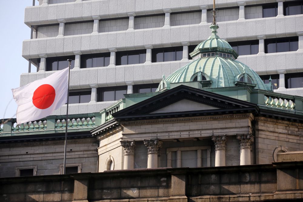 A Japanese flag flies atop the Bank of Japan (BOJ) headquarters in Tokyo, Japan, on Tuesday, March 17, 2015. Haruhiko Kuroda, governor of the Bank of Japan (BOJ), said he couldn't rule out the risk of consumer prices falling in Japan after the central bank on Tuesday maintained record monetary stimulus. Photographer: Yuriko Nakao/Bloomberg via Getty Images