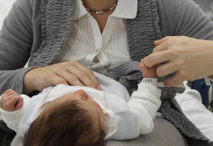 Una donna con il figlio neonato ripresa nella divisione ostetricia dell'ospedale Civile di Padova, il 2 gennaio 2012. ANSA / DAVIDE BOLZONI