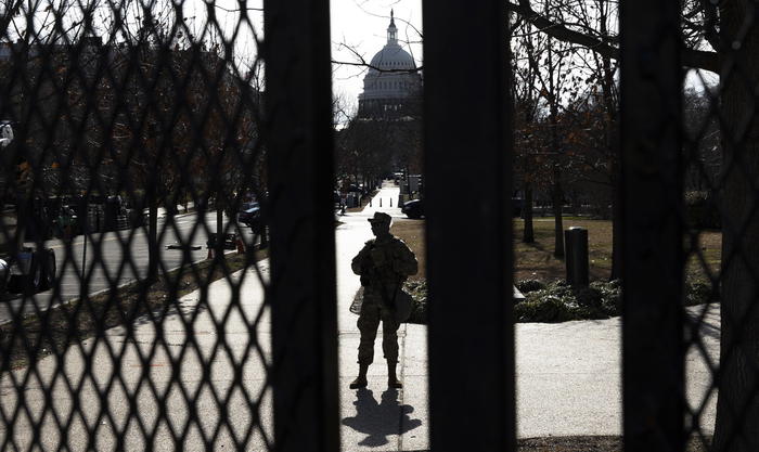 epa08942610 A National Guard soldier stands guard at the fence line around the US Capitol building in Washington, DC, USA, 16 January 2021. At least twenty thousand troops of the National Guard and other security measures are being deployed in Washington to help secure the Capitol area in response to potentially violent unrest around the inauguration of US President-elect Joe Biden.  EPA/JUSTIN LANE