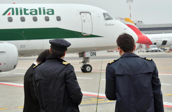 Due piloti di Alitalia osservano la partenza di un aereo all'aeroporto di Linate, 27 aprile 2017. Ansa/Daniel Dal Zennaro