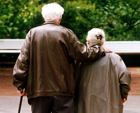 Una coppia di anziani a passeggio in un giardino 
 ANSA