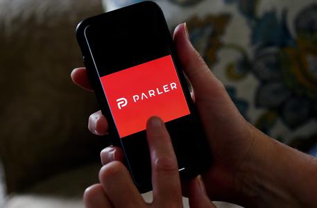 (FILES) This illustration file photo taken on July 2, 2020 shows social media application logo Parler displayed on a smartphone in Arlington, Virginia. - Apple on January 9, 2021, followed Google and removed the Parler app from its mobile store for allowing 
