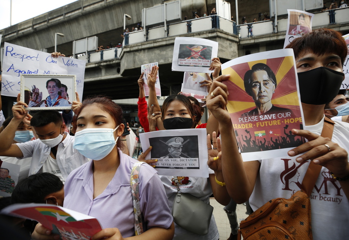 epaselect epa09001493 Myanmar people living in Thailand, hold pictures of Myanmar democracy icon Aung San Suu Kyi and the defaced pictures of Myanmar's army chief Senior General Min Aung Hlaing, during a protest against the Myanmar military coup, in city of Bangkok, Thailand, 10 February 2021. The gathering to express the Myanmar people in Thailand still continue after Myanmar's Aung San Suu Kyi and other top political leaders have been detained after a raid in a military coup due to a tension rising between civilian government and the military disputed from the November 2020 elections results.  EPA/NARONG SANGNAK