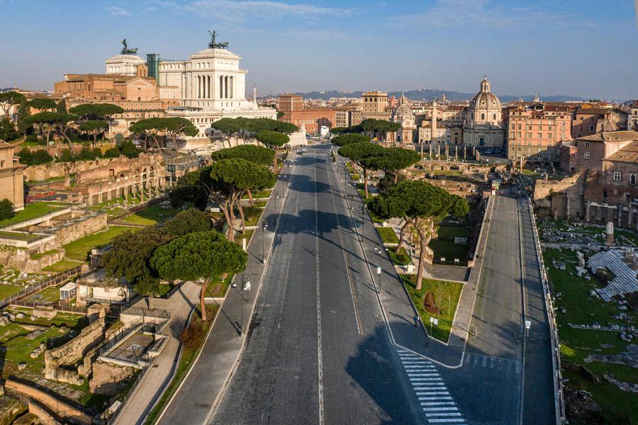 A morning aerial photo taken on March 30, 2020 shows a deserted Via dei Fori Imperiali (C) the Roman Forum (L), Trajan Forum (C-R) and Augustus Forum (R) in Rome during the country's lockdown aimed at curbing the spread of the COVID-19 infection, caused by the novel coronavirus. (Photo by Elio CASTORIA / AFP)