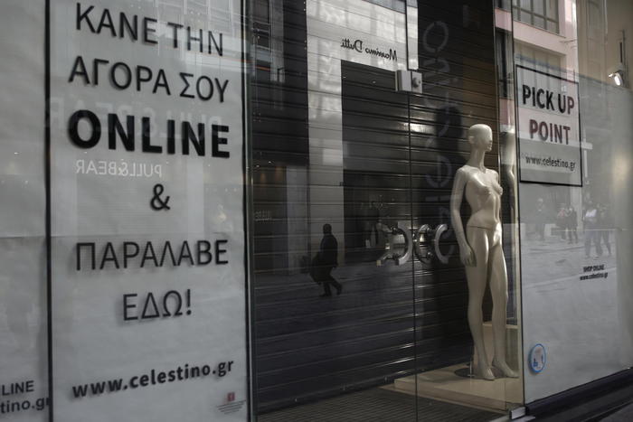 epaselect epa08916571 A window of a closed shop, advertising online and pick-up orders, during the first day of implementation of the new restrictive measures against Covid-19, in central Athens, Greece, 3 January 2021. Stricter week-long restriction measures to manage the rise in coronavirus cases went into effect on 03 January, following an announcement of the Greek government. The measures include a night curfew from 21:00 to 05:00 next morning, suspension of pick-up orders at retail stores (