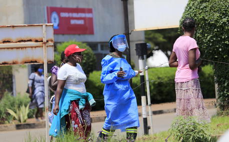 epa08931574 A health worker (C) puts on protective gear at Parirenyatwa Hospital in Harare, Zimbabwe, 11 January 2021. Zimbabwe could receive its first batch of the COVID-19 vaccine in February 2021, through an initiative led by the World Health Organisation (WHO) known as Covax.  EPA/AARON UFUMELI