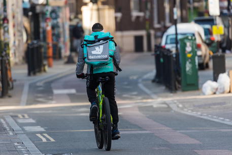 epa08327233 A deliveroo cyclist seen on empty streets in Brick Lane, east London, Britain, 27 March 2020. Britain's prime minister Boris Johnson has implemented social distancing measures banning social gatherings and groups of more than two people amid the ongoing coronavirus COVID-19 pandemic. People must stand more than two metres apart. Several European countries have closed borders, schools as well as public facilities, and have cancelled most major sports and entertainment events in order to prevent the spread of the SARS-CoV-2 coronavirus causing the Covid-19 disease.  EPA/VICKIE FLORES