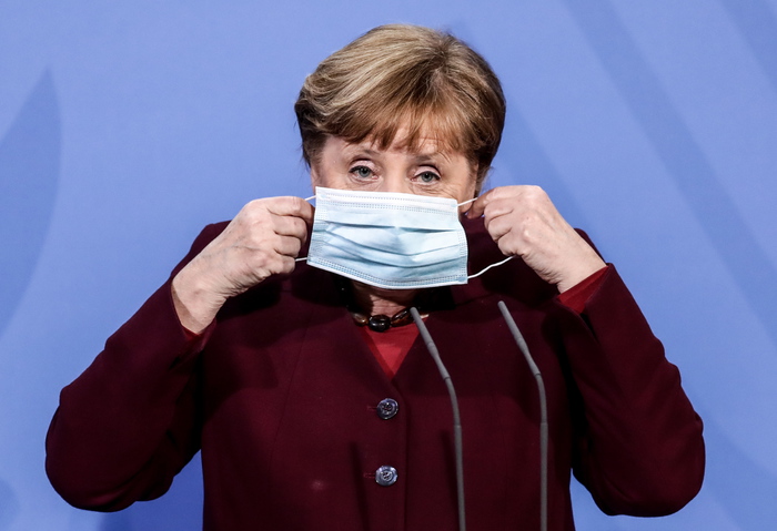 epaselect epa09084344 German Chancellor Angela Merkel puts on her face mask after a press conference after discussion with the heads of federal governments on the coronavirus vaccination strategy at the Federal Chancellery, Berlin, Germany, 19 March 2021.  EPA/FILIP SINGER / POOL