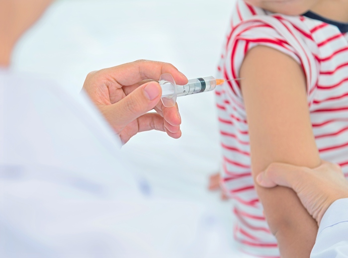 Little asian boy receives vaccine injection