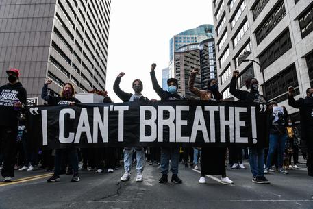 Demonstrators hold a banner during the Â“I CanÂ’t Breathe - Silent March for JusticeÂ” in front of the Hennepin County Government Center on March 7, 2021, where the trial of former Minneapolis police officer Derek Chauvin, charged with murdering African American man George Floyd, will begin on March 8, 2021, in Minneapolis, Minnesota. - His name is chanted by demonstrators around the globe. His face is displayed on murals all over the United States. Since his brutal death George Floyd has embodied, more than any other, the Black victims of police violence and racism in the United States. (Photo by CHANDAN KHANNA / AFP)