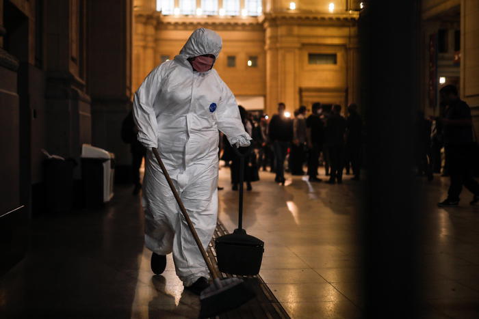 epa08383059 A cleaning employee disinfects the entrance to the Constitucion railway station in the City of Buenos Aires, Argentina 24 April 2020, as the government is expected to announce the extension of mandatory and social preventive isolation.  EPA/Juan Ignacio Roncoroni