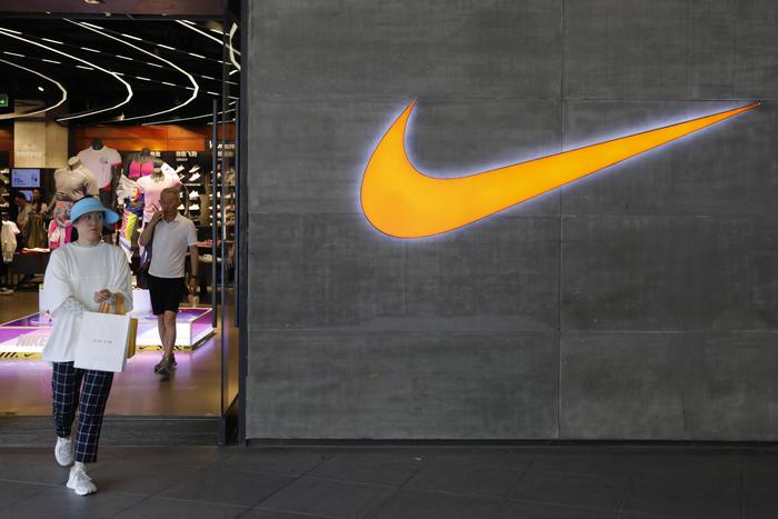 epa07591450 A Chinese woman walks past a logo of Nike outside Nike store in Beijing, China, 22 May 2019. A letter signed by 173 companies which including Nike, Adidas, says the US President's decision to raise import tariffs to 25 percent will disproportionately affect the working class after Donald J. Trump increased levies on 200 billion US dollars worth of Chinese imports into the US from 10 percent to 25 percent.  EPA/WU HONG