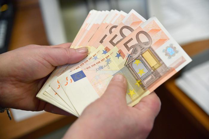 Alcune banconote da 50  Euro in mano a un cassiere di una banca. 16 aprile 2018 a Genova ANSA/LUCA ZENNARO