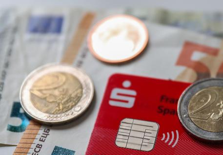 epa07363630 Some banknotes and coins are seen together with a credit card with an integrated NFC technology chip for cash-less payment in a shop in Frankfurt am Main, Germany, 12 February 2019. Later on 12 February the German Federal Bank 'Bundesbank' will present the results of a study 'on Costs of cash payments in retail trade'.  EPA/ARMANDO BABANI