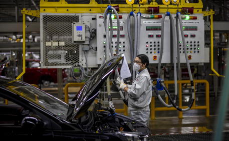 epa08746780 A man works in Dongfeng Yueda KIA Motors factory in Yancheng, Jiangsu province, China, 15 October 2020. Dongfeng Yueda KIA Motors Plant 3 was put into operation in Yancheng, Jiangsu in early 2014, with an annual production capacity of 450,000 vehicles per year. It is currently KIAÂ’s worldÂ’s biggest modern plant. It has a fully automatic production line composed of press, body, paint, assembly, and engine workshops.  EPA/ALEX PLAVEVSKI