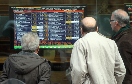 Alcune persone osservano il listino di Piazza Affari, oggi 9 novembre 2011, attraverso un monitor di una banca di Milano.
MATTEO BAZZI / ANSA