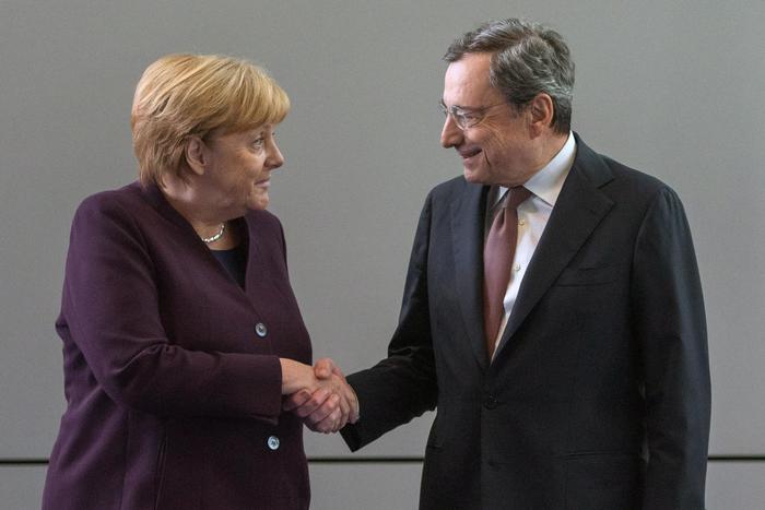 Outgoing ECB president Mario Draghi (R) shakes hands with German chancellor Angela Merkel during Draghi's farewell and bell handing over to Christine Lagarde (not pictured) at the headquarters of the European Central Bank, Frankfurt, Germany, 28 October 2019 (issued 29 October 2019). ANSA/BERND KAMMERER / POOL