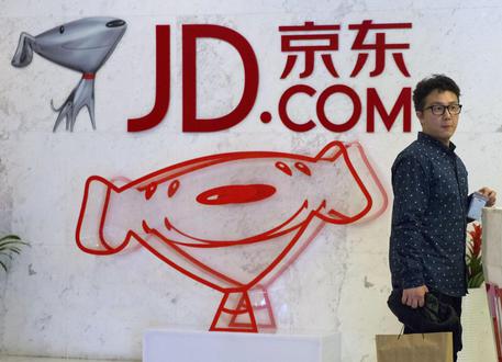 FILE - In this April 2, 2015 file photo, a visitor waits at the entrance to JD.com's head office in Beijing. JD.com, Executives from five major brands told AP that after they refused exclusive deals with Alibaba and instead participated in big promotions with its archrival JD.com, traffic to their products on Alibaba's Tmall fell, hurting sales. Alibaba says it has never punished anyone. (ANSA/AP Photo/Ng Han Guan, File) [CopyrightNotice: Copyright 2018 The Associated Press. All rights reserved.]
