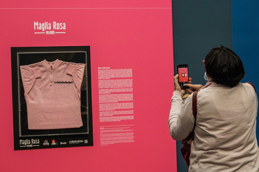 epa09182818 A visitor takes a picture of the Maglia Rosa of Italian cycling legend Fausto Coppi, exhibited at the Museo Egizio in Turin, Italy, 07 May 2021. The Giro d'Italia overall leader's pink jersey celebrates its 90th anniversary. The 104th edition of the Giro d'Italia will take place from 08 May through 30 May 2021.  EPA/Tino Romano
