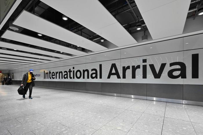Passengers arrive with lugagge at the Terminal 5 international arrivals hall at London Heathrow Airport in west London on February 14, 2021 . - A new 10-day hotel quarantine regime for travellers arriving in the UK from 33 coronavirus variant hotspots begins on February 15, despite concern from the country's busiest airport Heathrow that 